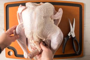 removing the innards from a raw turkey on a cutting board