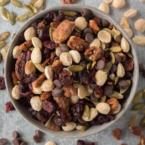 trail mix in a bowl with ingredients spread around it
