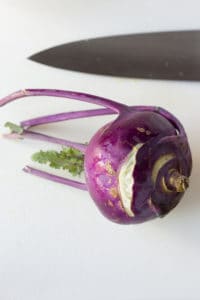a kohlrabi on a cutting board with a knife