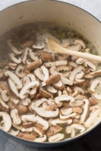 mushrooms added into a pot with turkey rice soup