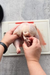 taking the internal organ bag out of a raw chicken