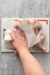 drying a raw chicken with a paper towel