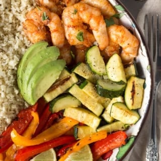 top down shot of a grilled shrimp bowl with veggies and cauliflower rice