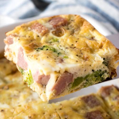 a piece of ham and broccoli egg casserole being held on a spatula