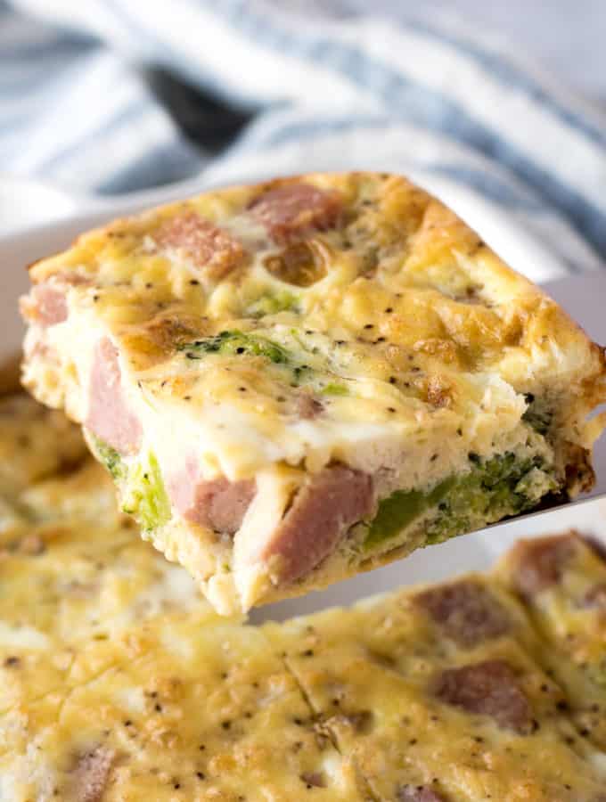 a piece of ham and broccoli egg casserole being held on a spatula