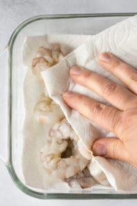 drying raw shrimp off with paper towels