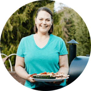 taryn solie from hot pan kitchen holding a white platter with grilled food on her deck
