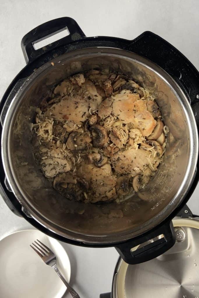 Top down shot of cooked chicken thighs and rice in an Instant Pot.