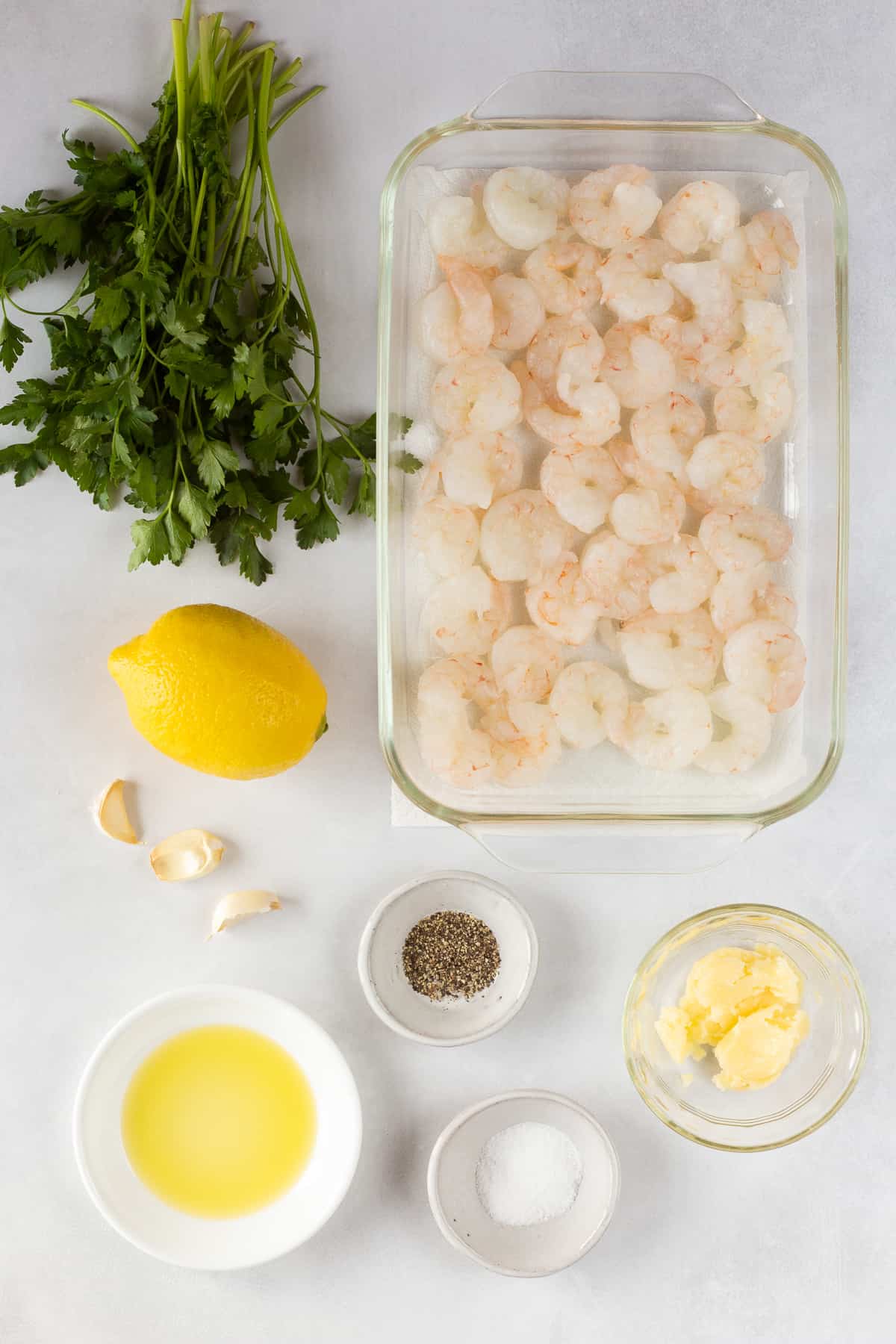 top down shot of ingredients for garlic shrimp on the traeger on a white background.