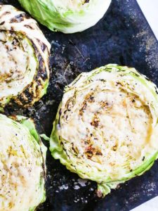Close up of roasted cabbage steaks on a sheet pan.