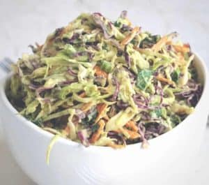 Close up of a coleslaw made without mayo in a small white bowl.