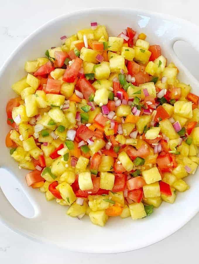 Top down shot of pineapple salsa in a large white serving dish.
