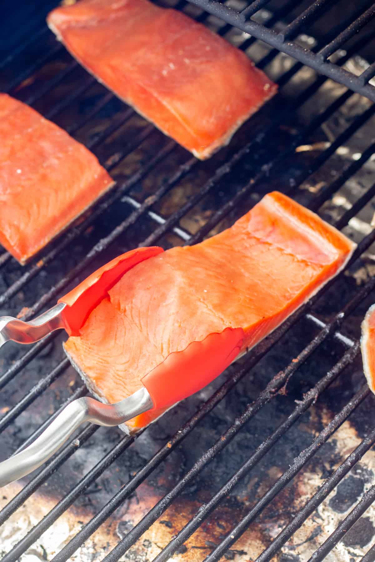 Close up of brined salmon being placed on a Traeger grill to smoke.