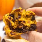 Close up of half a gluten free pumpkin chocolate chip muffin held in a hand
