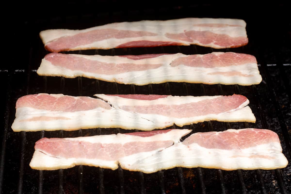 Close up of raw bacon on a Traeger grill