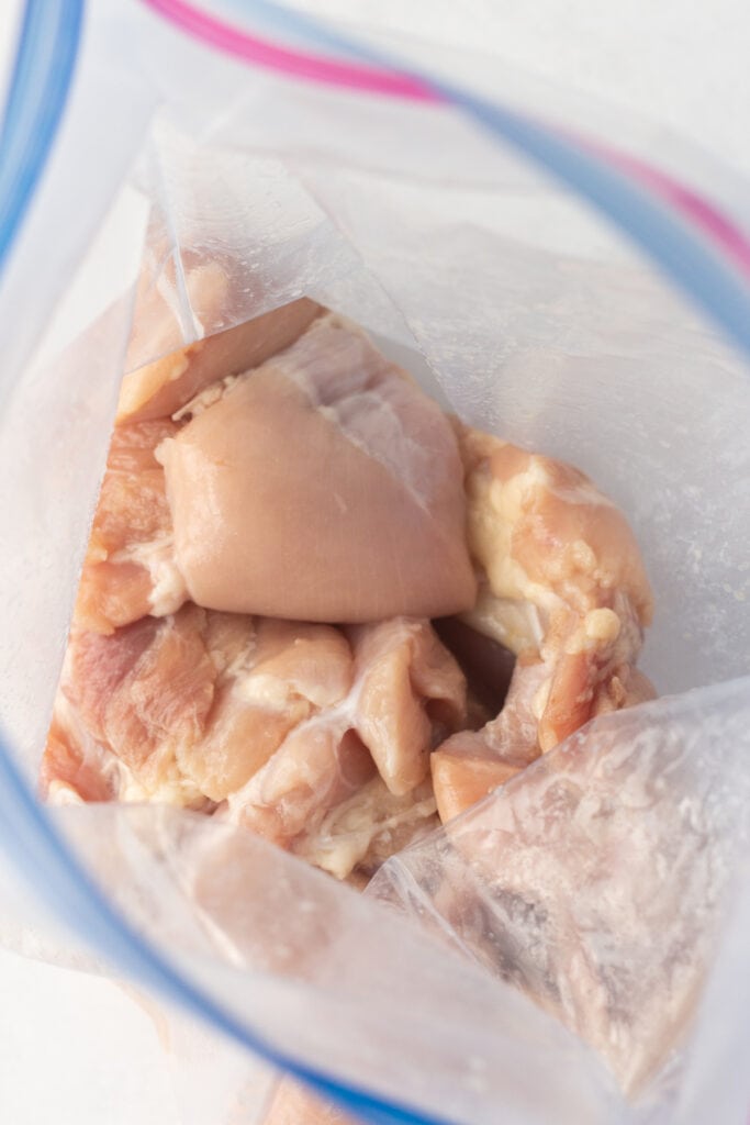 raw boneless skinless chicken thighs in a plastic ziploc bag.