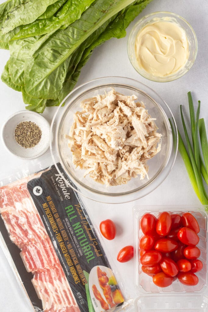 top down shot of ingredients for BLT chicken salad on a white background.