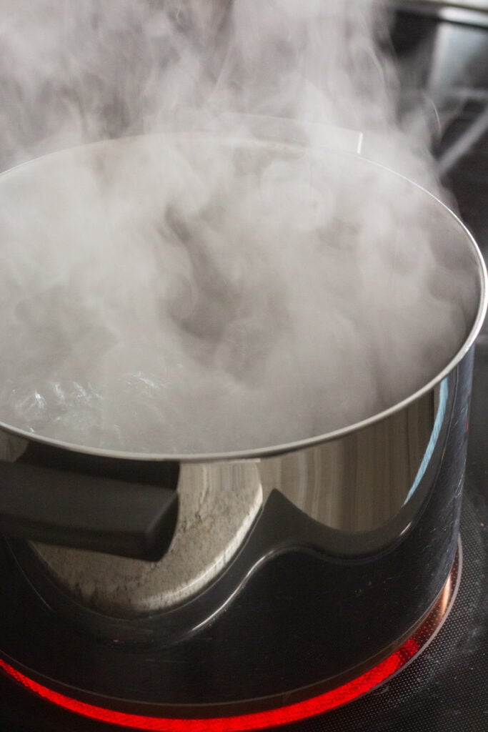 A large pot of water boiling on a stovetop.