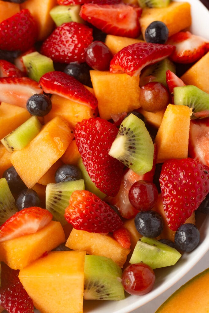 Close up of fruit salad in a large white bowl.