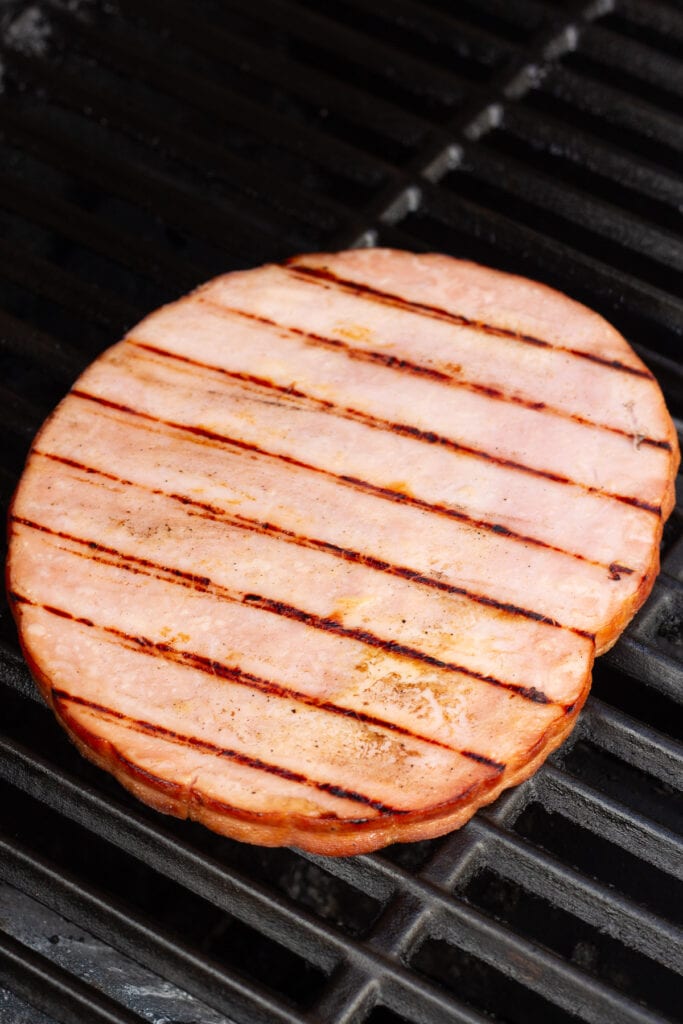 A ham steak on the grill.