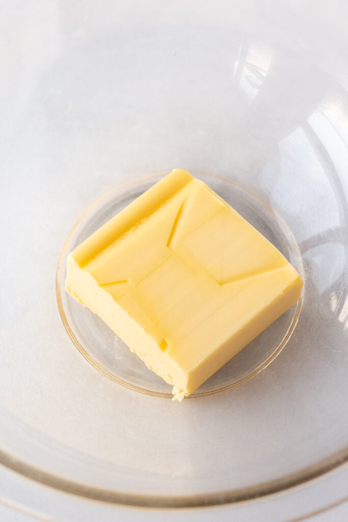 A half a cup of butter in a clear microwavable bowl.