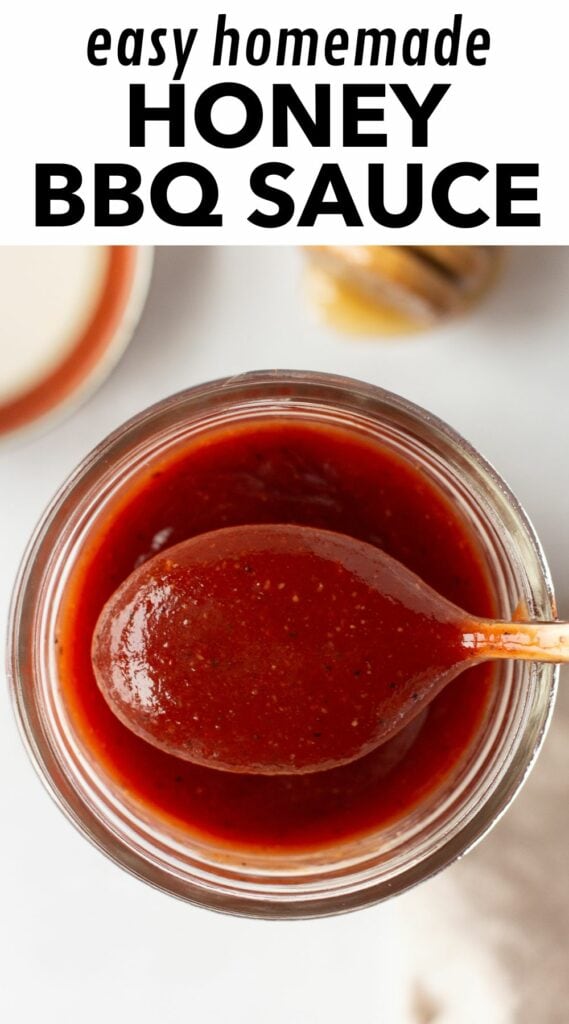 pin for honey bbq sauce showing a top down shot of a spoon holding the sauce over a small mason jar.