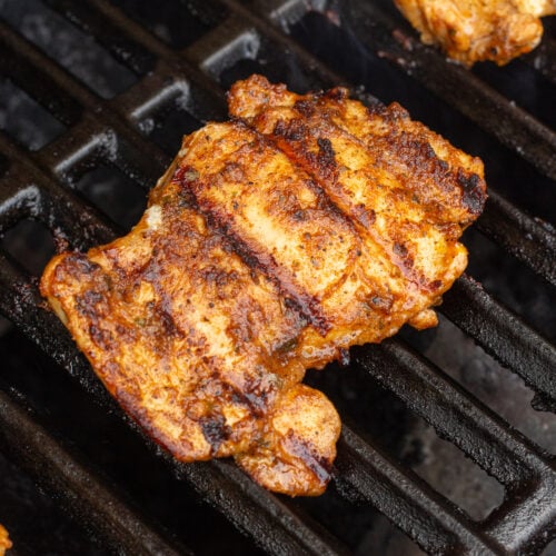 a boneless skinless chili lime chicken thigh being cooked on a gas grill.