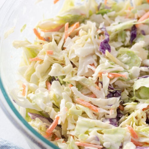 Close up of coleslaw in a large glass bowl.