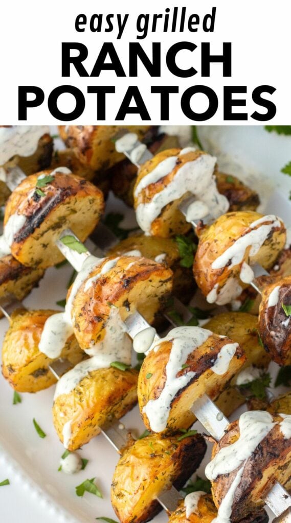 Pinterest image showing a close up of ranch grilled potatoes on metal skewers with ranch drizzled over them. At the top is a white rectangle with black text that reads "easy grilled ranch potatoes".