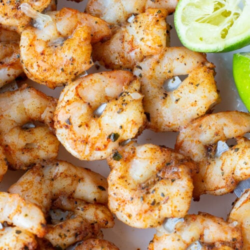 Close up of grilled chili lime shrimp on skewers.