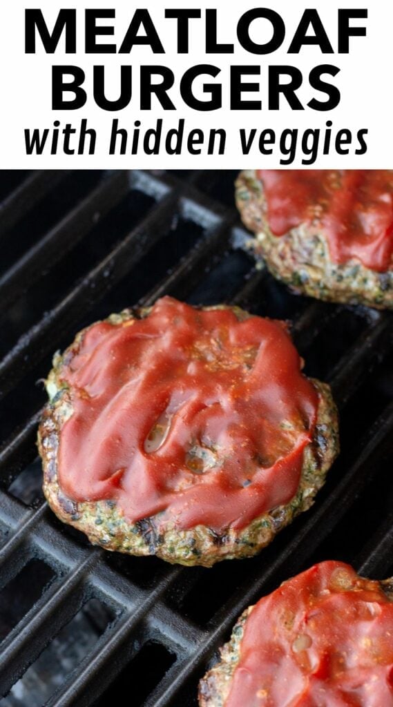 Pinterest image for grilled meatloaf burgers, showing a picture of meatloaf burgers on a grill with ketchup on top. The top portion of the image shows a white rectangle with black text reading "meatloaf burgers with hidden veggies".